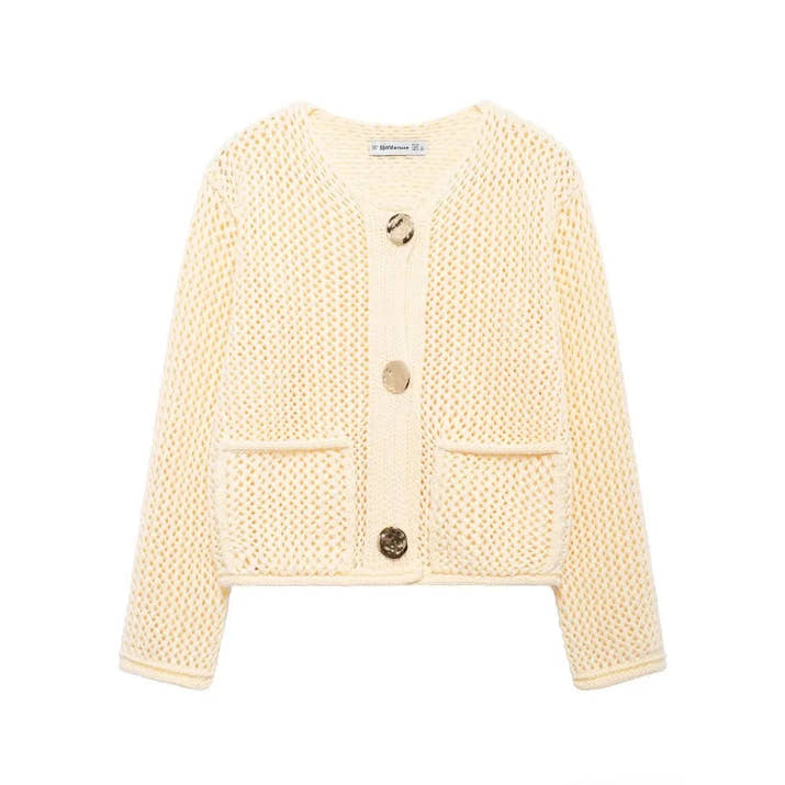 Cream-colored knitted cardigan with button details on a white background
