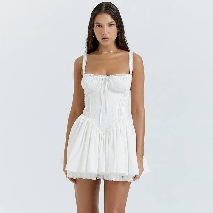 Woman wearing a white dress on a light gray background