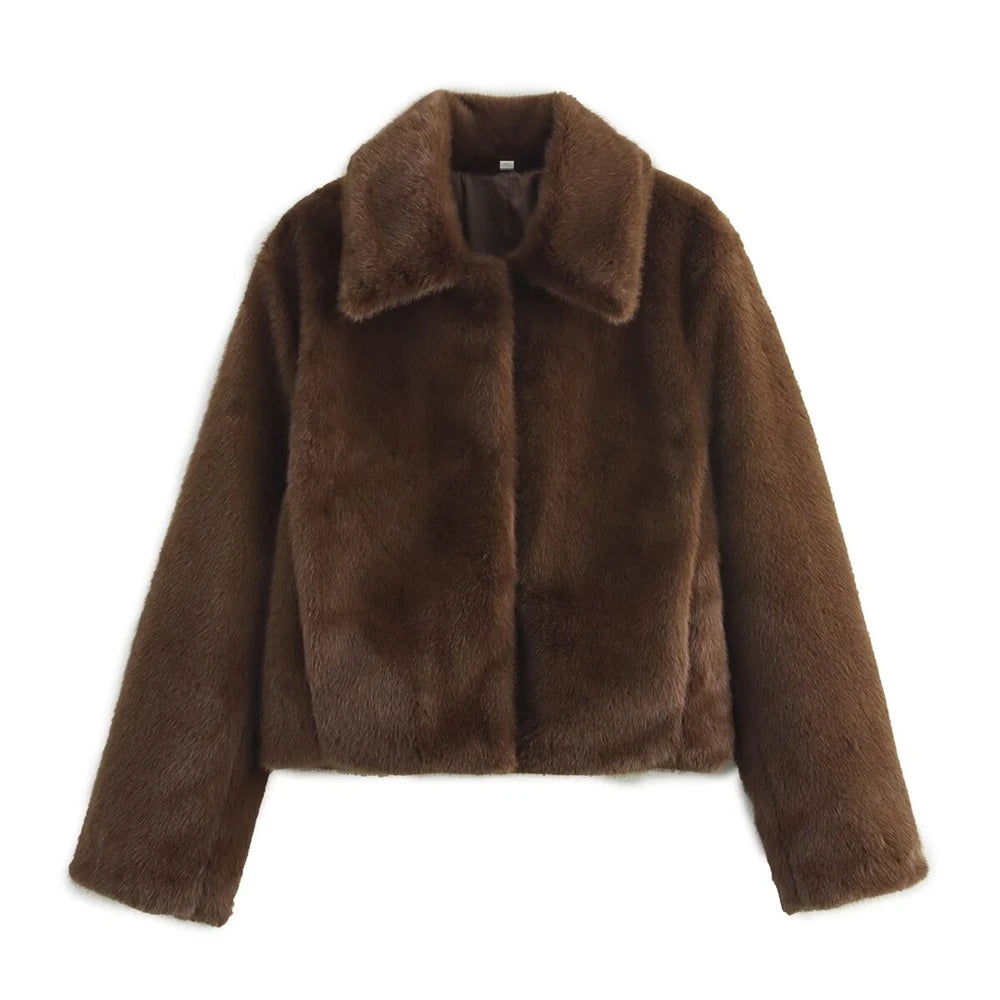 Woman wearing a brown faux fur winter jacket while sipping coffee outside a cozy café in cold weather.