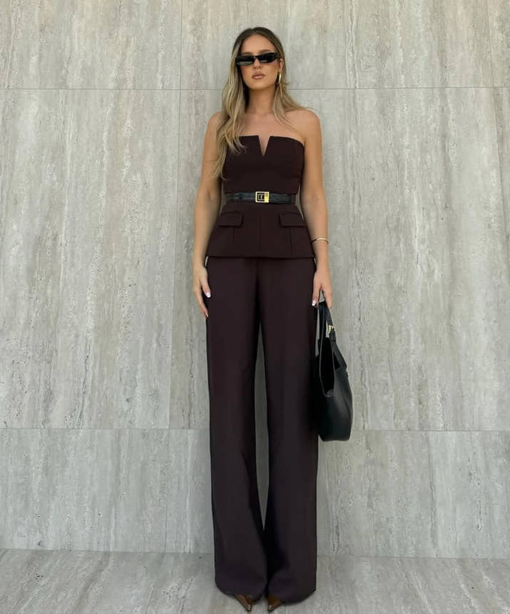 Woman wearing a strapless off white backless crop top, styled for office and club look.