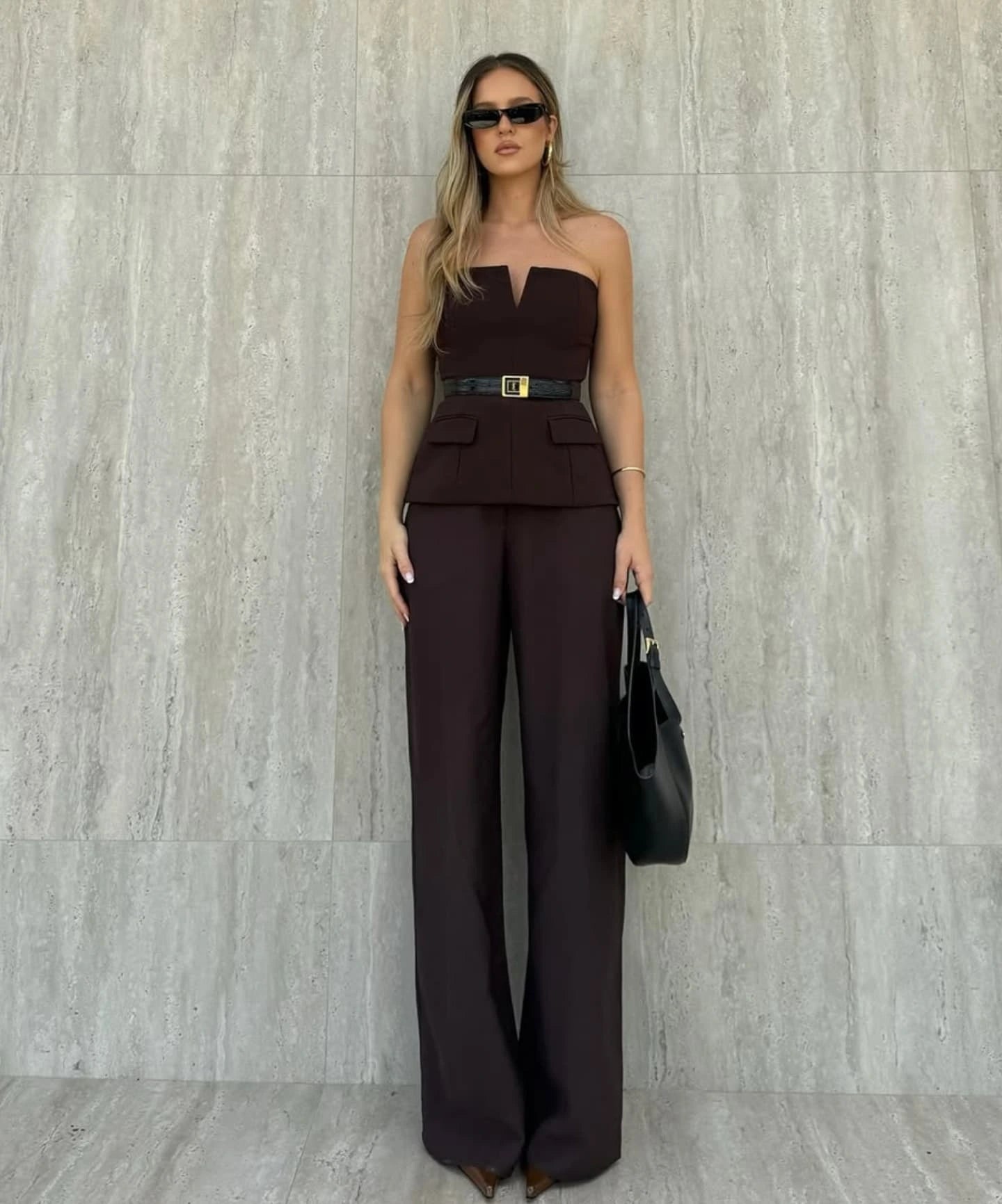 Woman wearing a strapless off white backless crop top, styled for office and club look.
