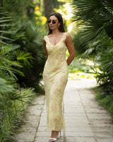 Woman in a yellow dress walking through a tropical garden