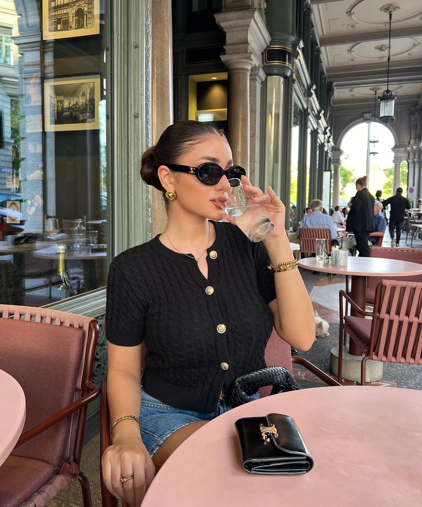 Woman wearing a slim fit solid color short sleeved knit cardigan, styled for autumn casual outings.