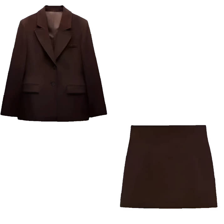 Woman wearing a slim-fit brown blazer jacket and A-line mini skirt in an office setting, confidently presenting in a modern workspace.
