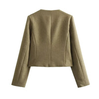 The woman looks casual and chic while walking around the city in a lightly cut khaki double-breasted tweed jacket with buttons.