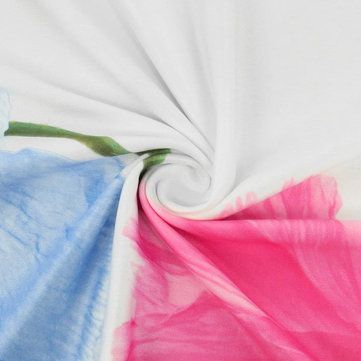 Close-up of colorful fabric with blue, pink, and green patterns on a white background