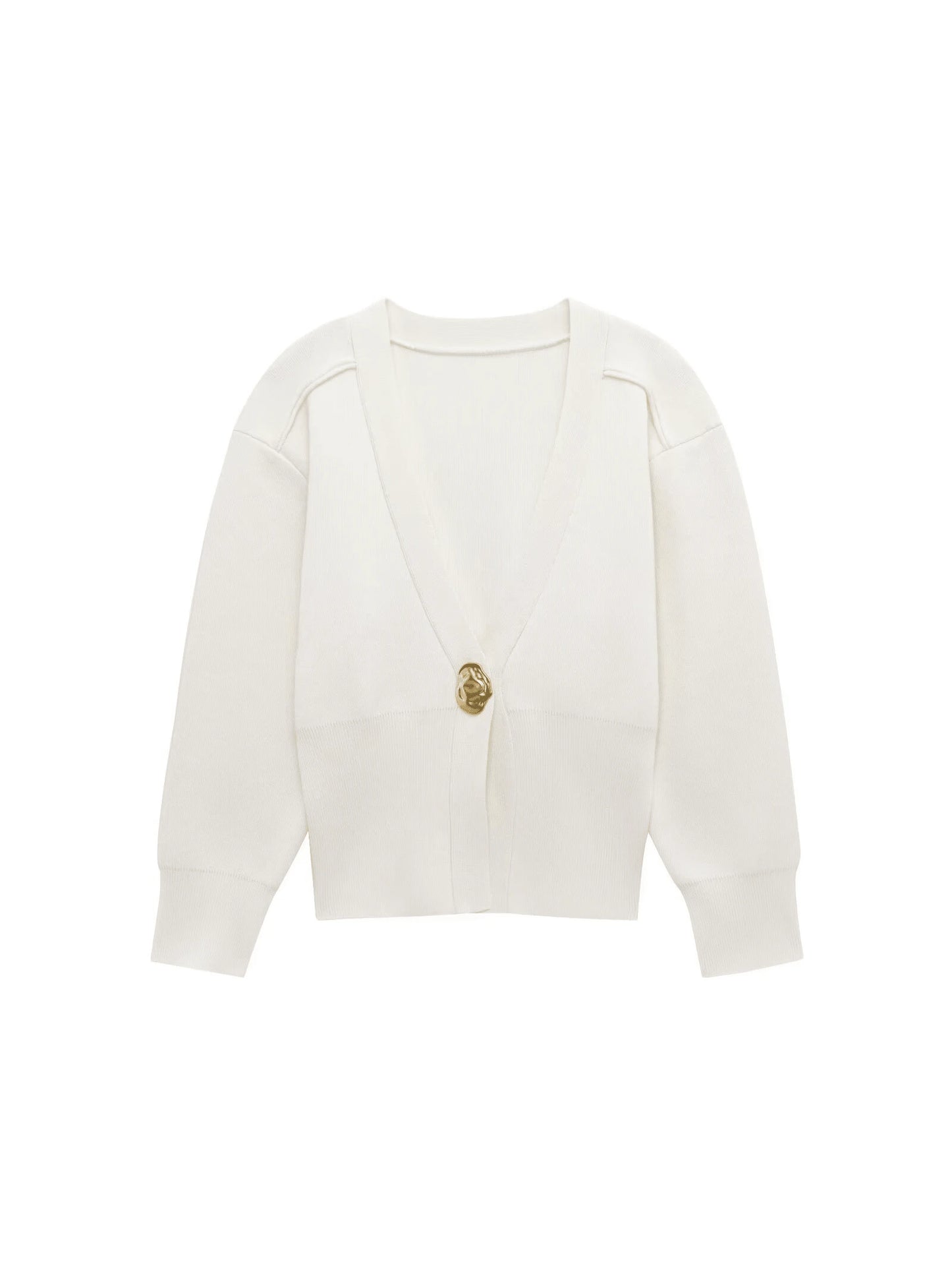 Model wearing a V-neck knit cardigan over a white tank top and trousers, enjoying a coffee outdoors in spring.