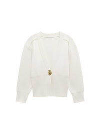 Model wearing a V-neck knit cardigan over a white tank top and trousers, enjoying a coffee outdoors in spring.