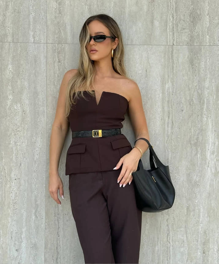 Woman wearing a strapless off white backless crop top, styled for office and club look.