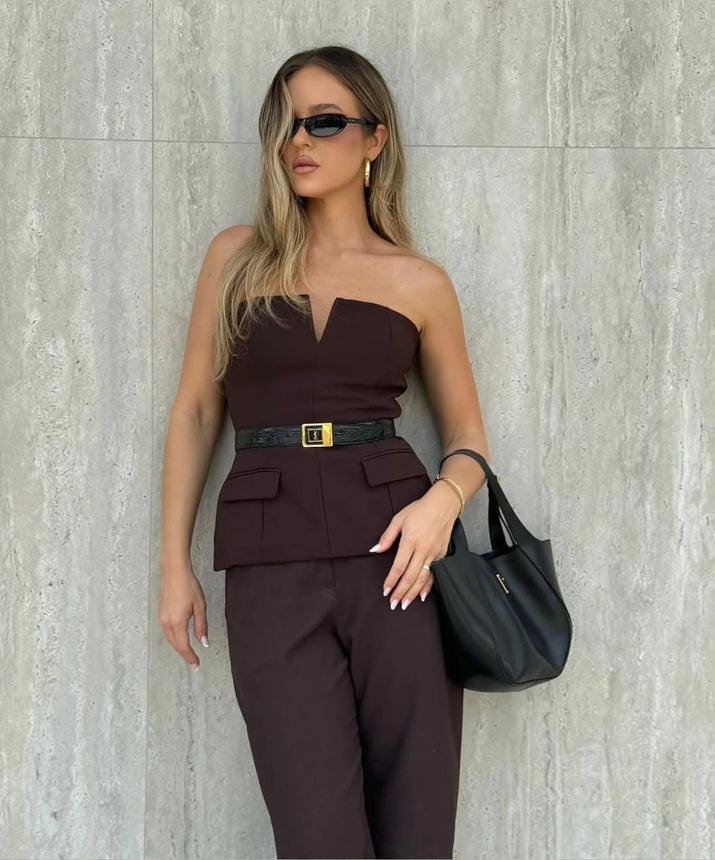 Woman wearing a strapless off white backless crop top, styled for office and club look.