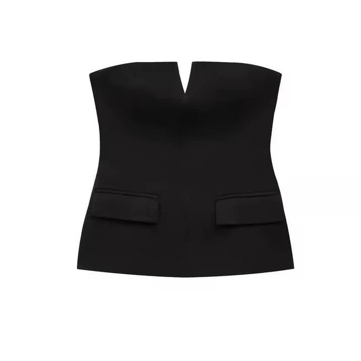 Woman wearing a strapless off white backless crop top, styled for office and club look.